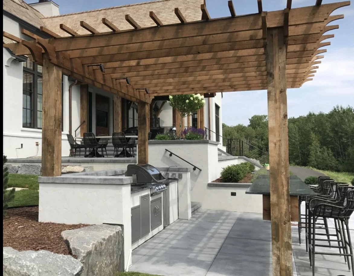 Outdoor living space with timber pergola, built-in grill, and concrete patio